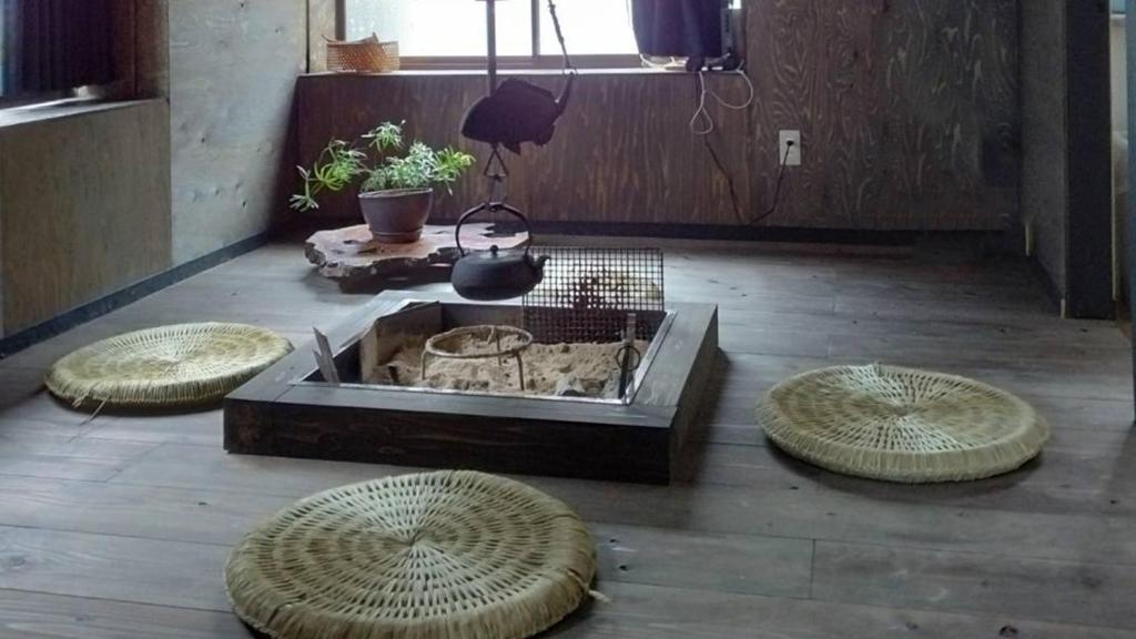 a living room with three tables and a fire pit at Kakomu - Vacation STAY 70352v in Kesennuma