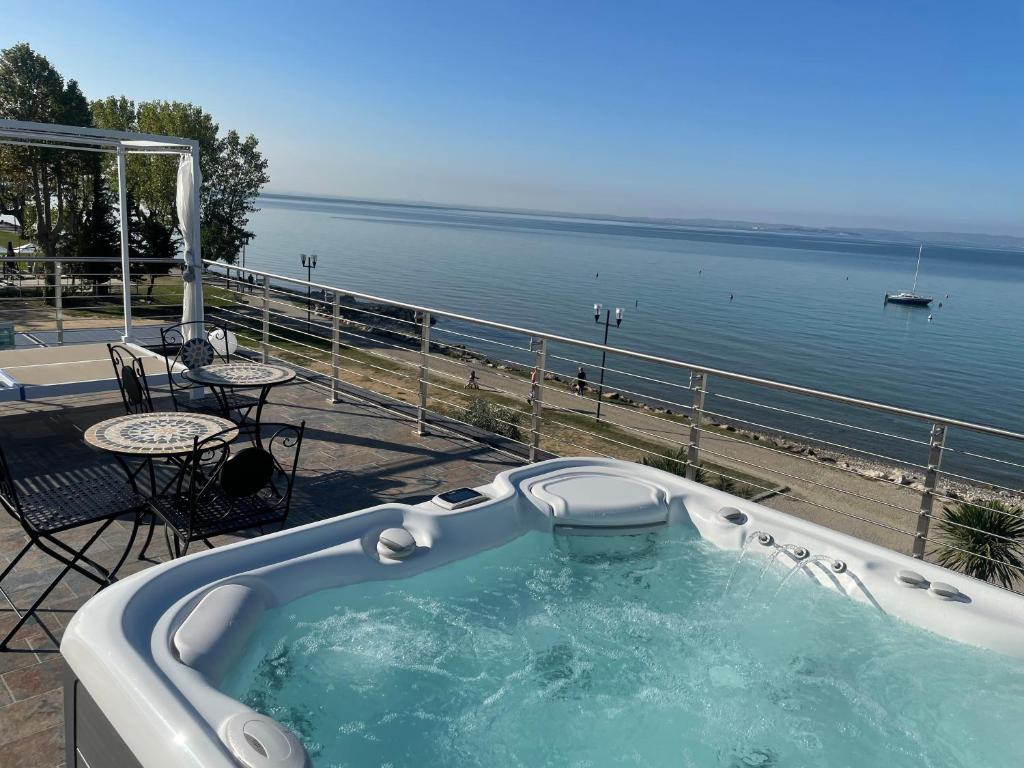 a jacuzzi tub on a patio next to the water at Bardolino Luxury in Bardolino
