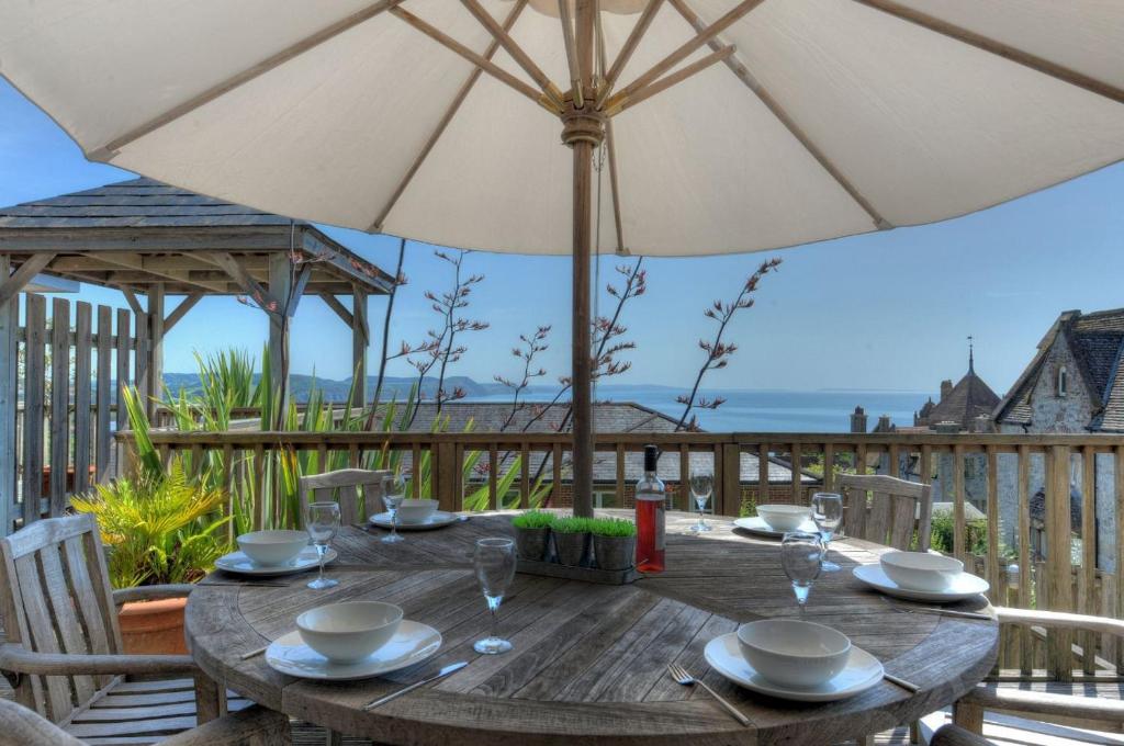 a wooden table with an umbrella on a deck at 4 Coram Court in Lyme Regis