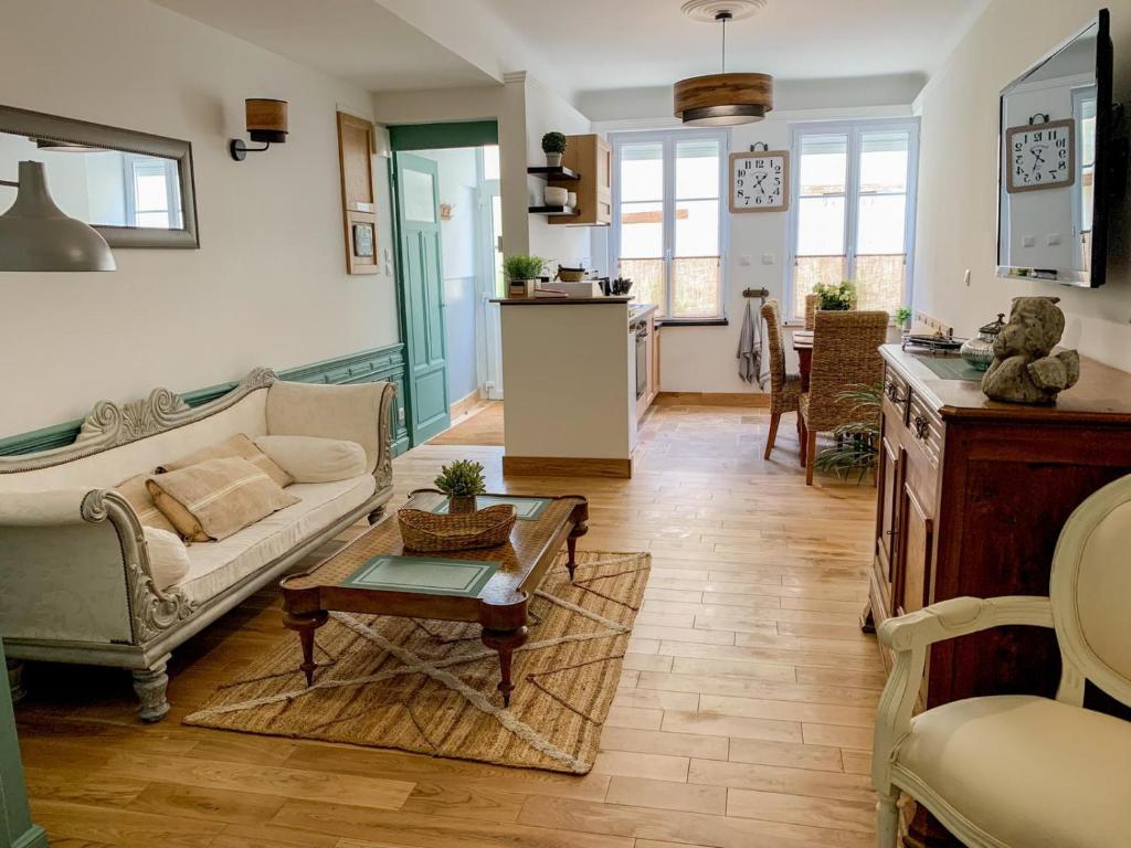 a living room with a couch and a table at Fontevraud Les Chambres in Fontevraud-l'Abbaye