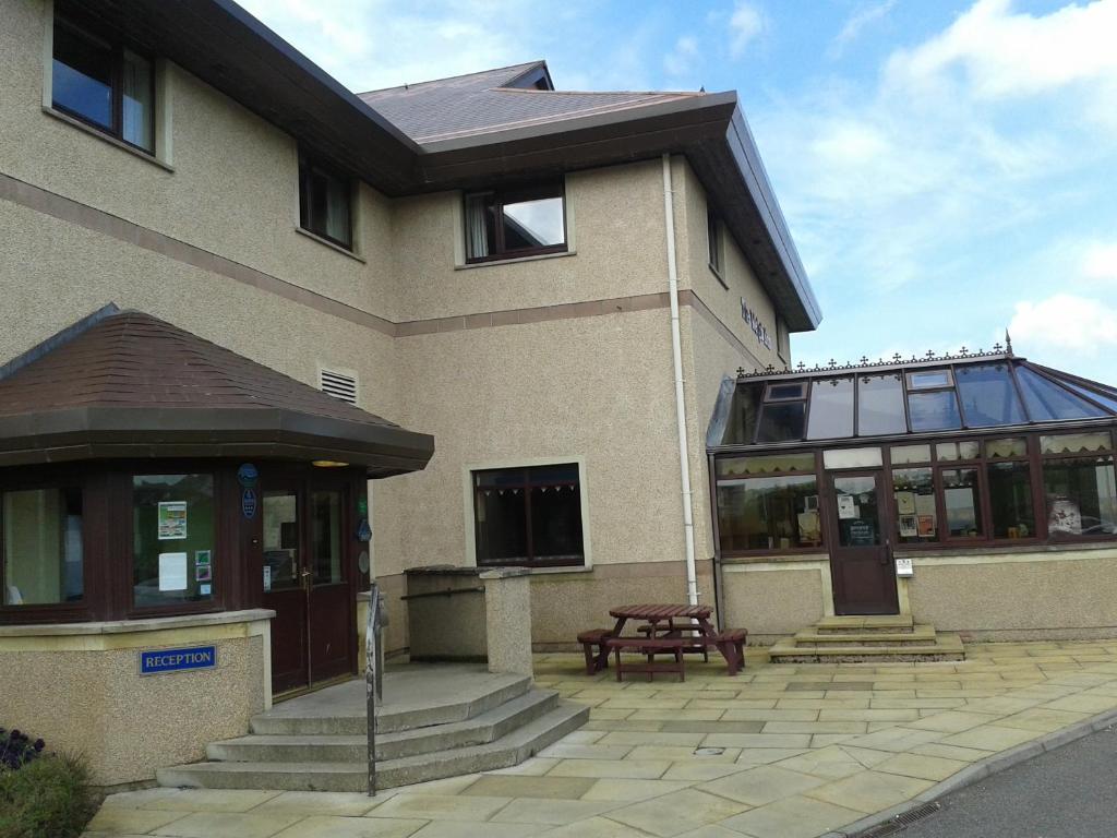 a building with a picnic table in front of it at The Weigh Inn Hotel & Lodges in Thurso
