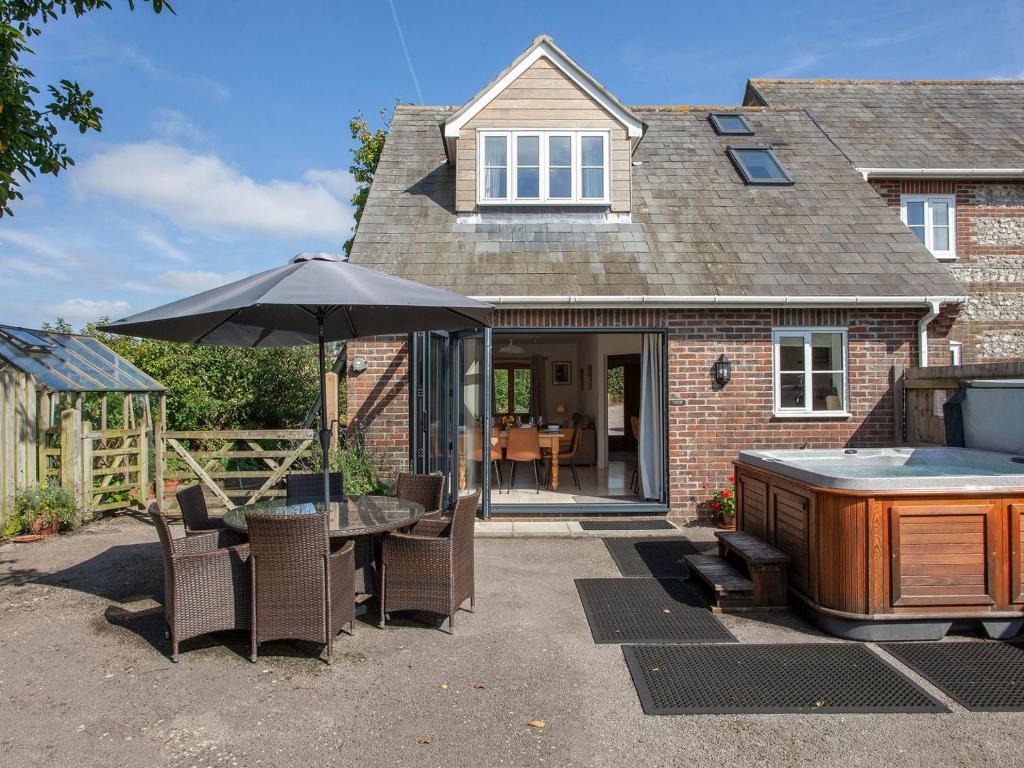 a patio with a table and an umbrella at Tokenhill Cottage in Piddletrenthide