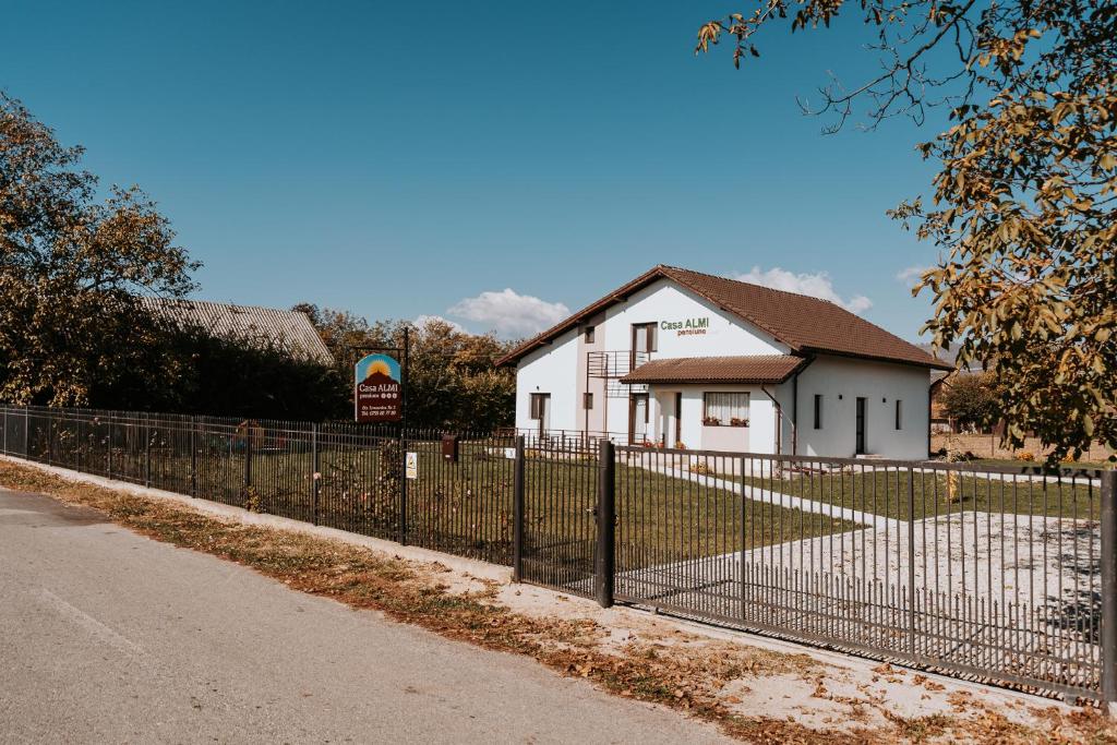 einen Zaun vor einem weißen Haus in der Unterkunft CASA ALMI in Polovragi