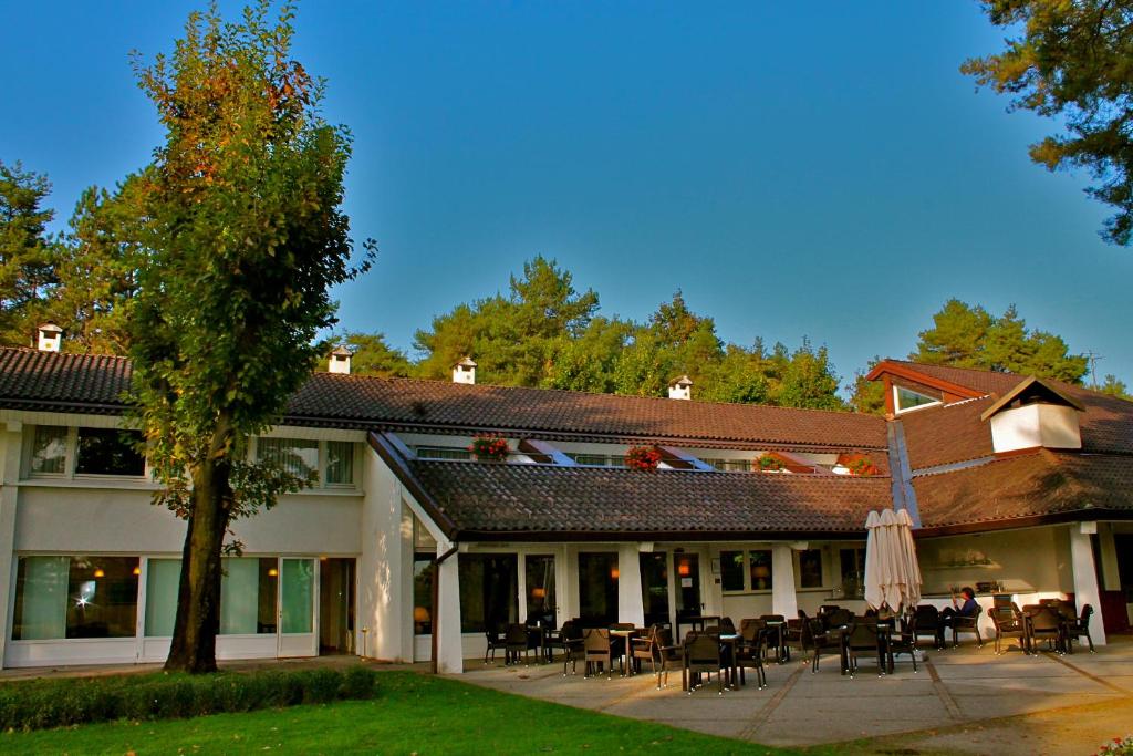 a building with tables and chairs in the courtyard at Golf Hotel La Pinetina in Appiano Gentile