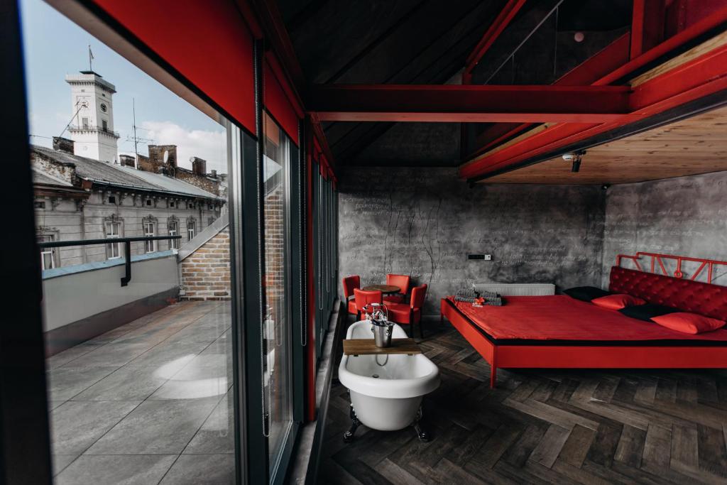 a bedroom with a red bed and a bath tub at Masoch. Hotel & Cafe in Lviv