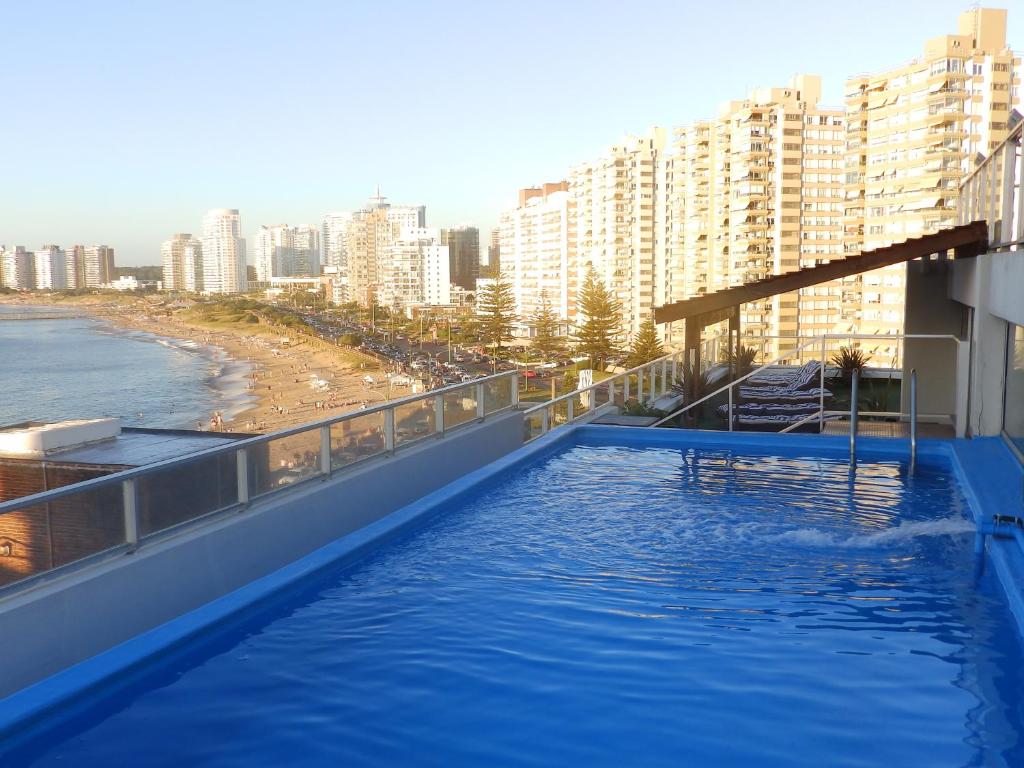 a swimming pool on top of a building next to a beach at Tanger Hotel in Punta del Este