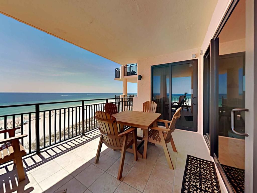 einen Balkon mit einem Tisch, Stühlen und Meerblick in der Unterkunft Seachase 701c in Orange Beach