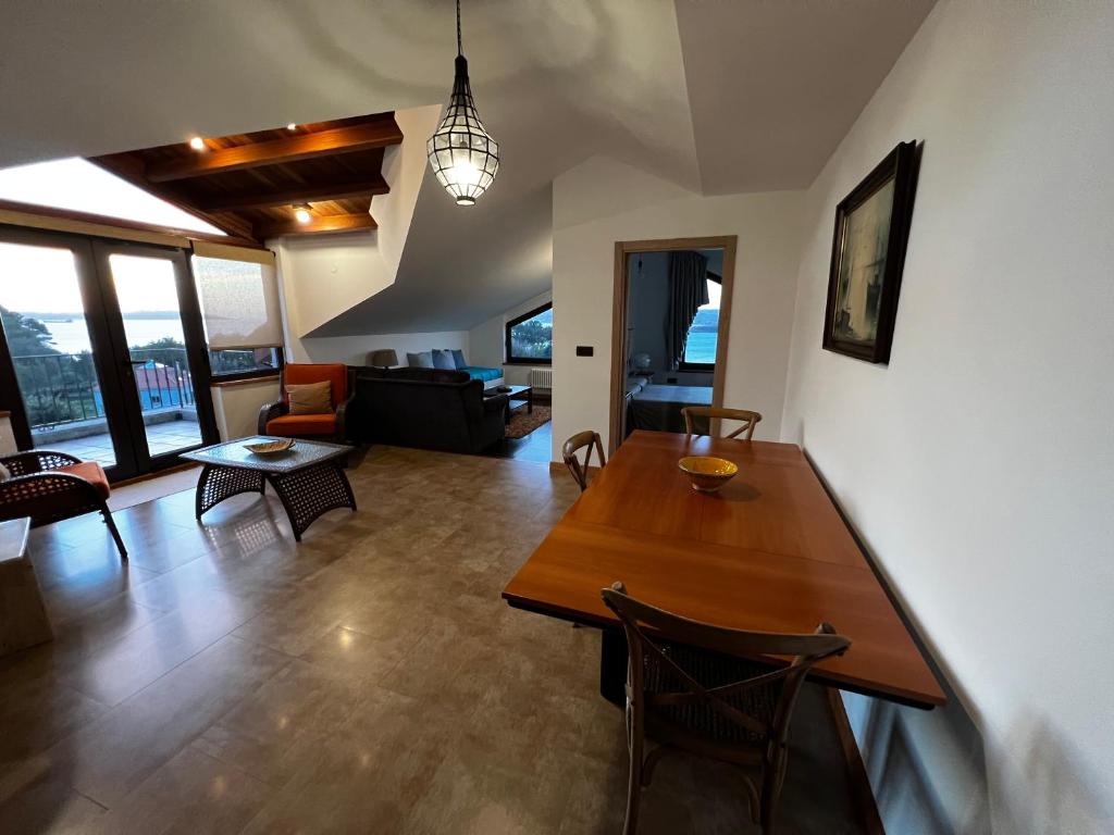 - un salon avec une table et des chaises en bois dans l'établissement A Marola By Oktheway, à Pontedeume