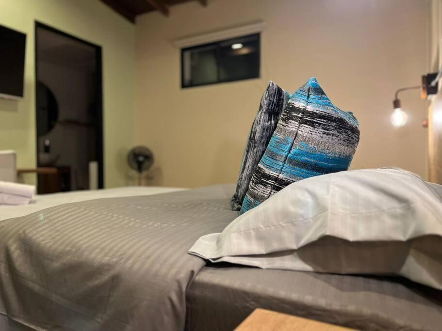 a bed with two pillows sitting on top of it at Inmueble cerca al estadio NID204 By Roots Rentals in Medellín