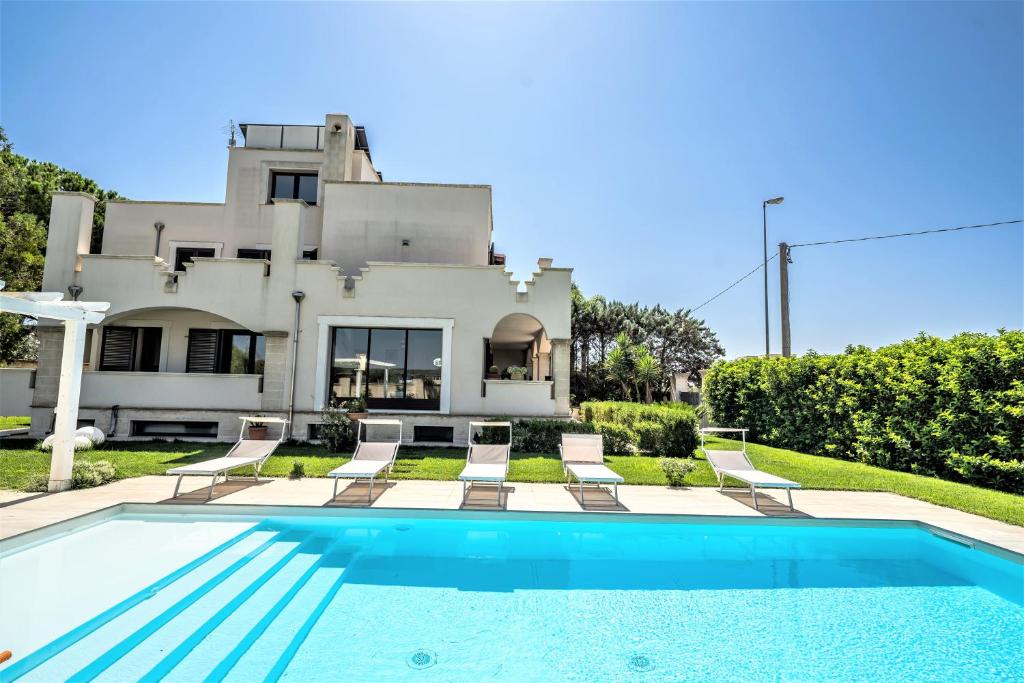ein Haus mit einem Pool vor einem Haus in der Unterkunft Villa Vespucci in Torricella