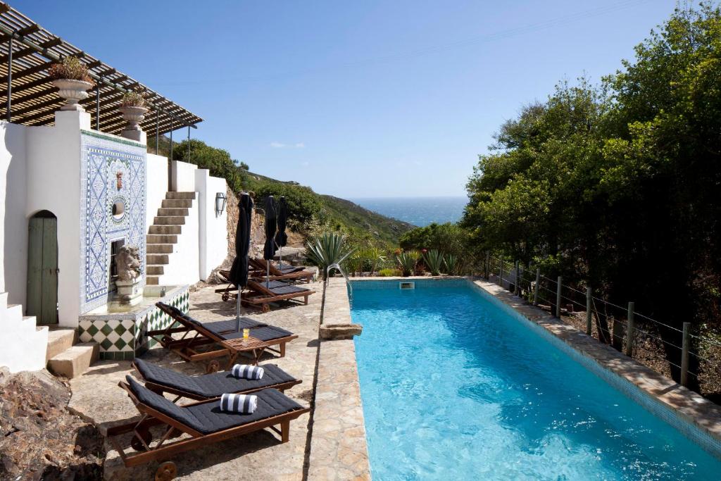 a swimming pool with lounge chairs and a villa at Convento de Sao Saturnino in Sintra