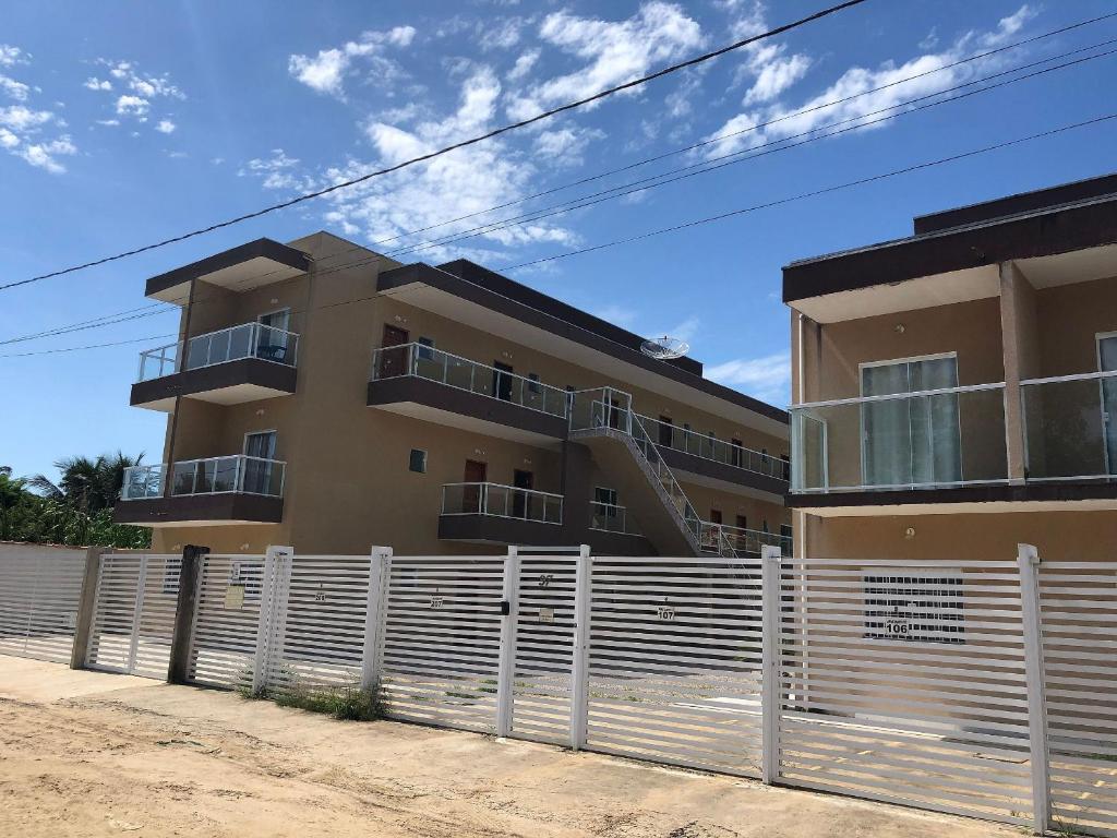 a building with a fence in front of it at Rafael Apartamentos 800m da Praia da Maranduba in Ubatuba