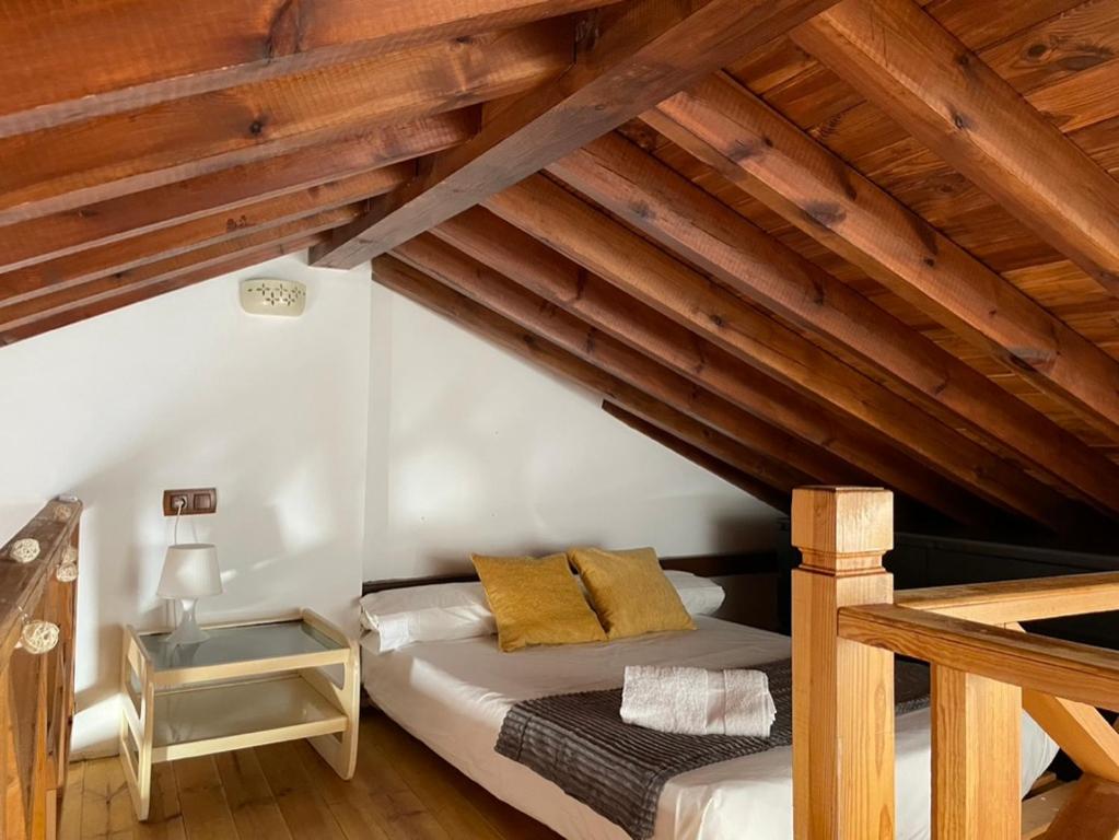 Cama en habitación con techo de madera en Al-Mansur en Granada