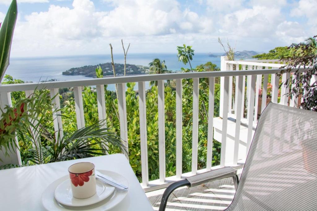 eine Tasse Kaffee auf einem Tisch auf einem Balkon in der Unterkunft Morne SeaView Apartments in Castries