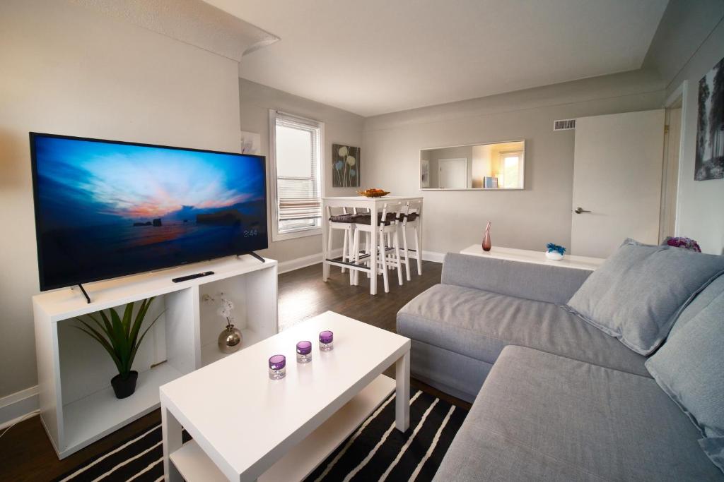 a living room with a couch and a flat screen tv at Hamilton Mountain Plaza - King Bed - Free Parking in Hamilton