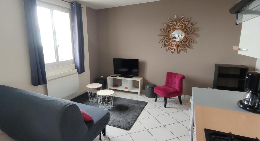 uma sala de estar com um sofá e uma cadeira vermelha em Le relais de La Poste 1 em Colombey-les-deux-Églises