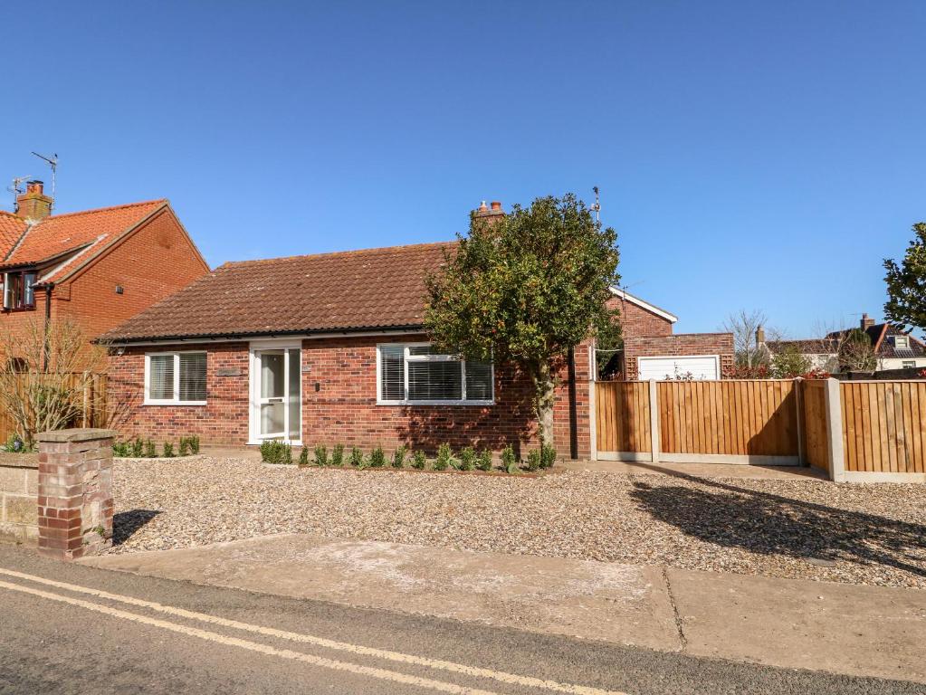 a brick house with a fence and a driveway at Sunnyside in Wells next the Sea