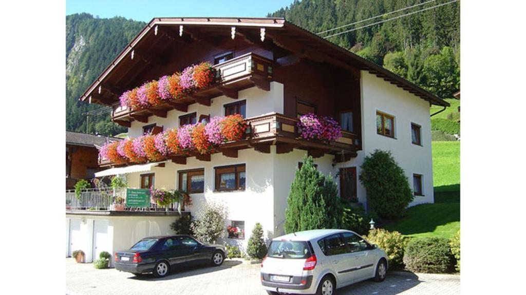 una casa con flores a un lado. en Gästehaus Emberger, en Mayrhofen