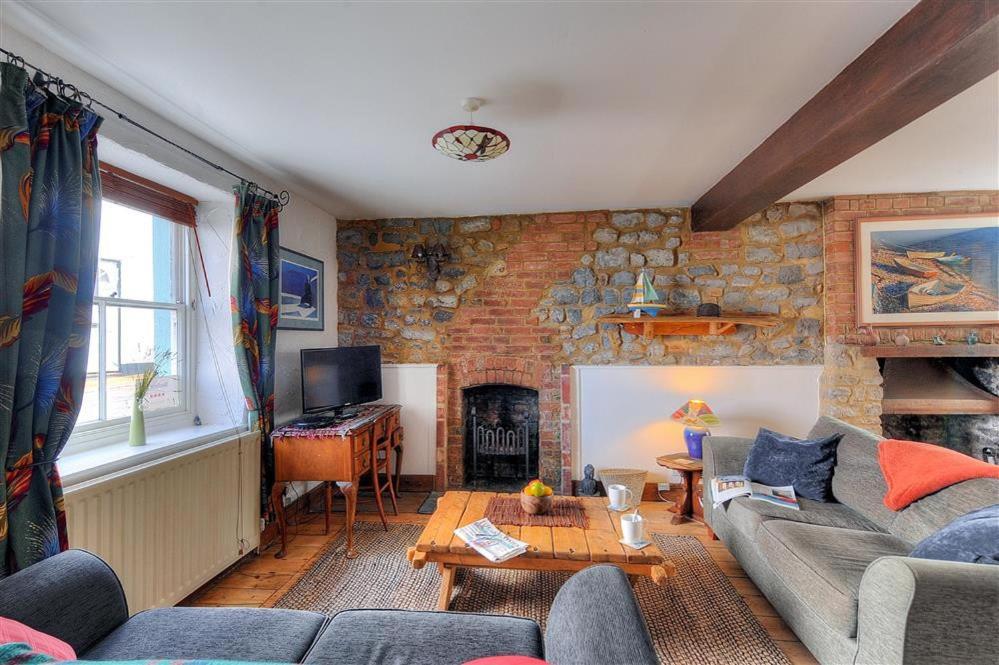 a living room with a couch and a fireplace at Bedrock in Lyme Regis