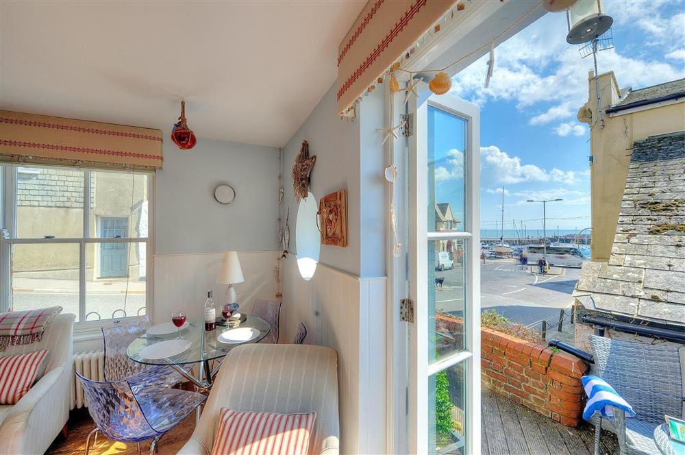 a living room with a table and a window at Seaside in Lyme Regis