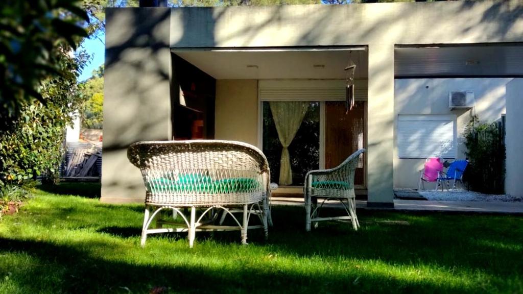 dos sillas sentadas en el césped frente a una casa en Residencias de Mar 1 en Monte Hermoso