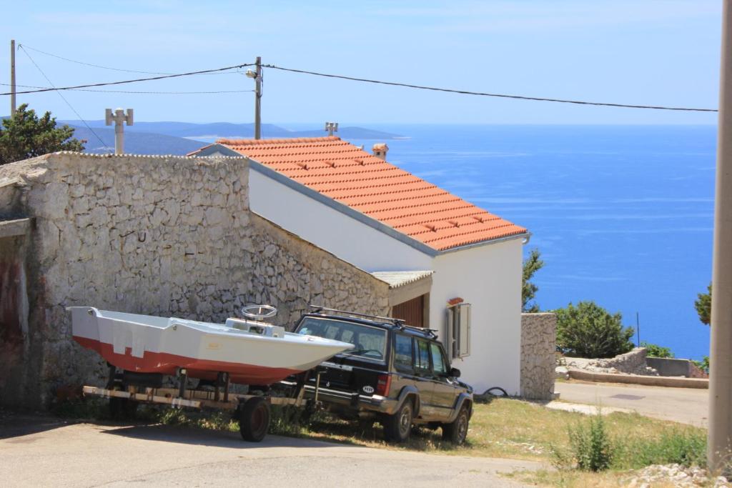 a boat on a trailer in front of a house at Holiday house with WiFi Ustrine, Cres - 8037 in Ustrine
