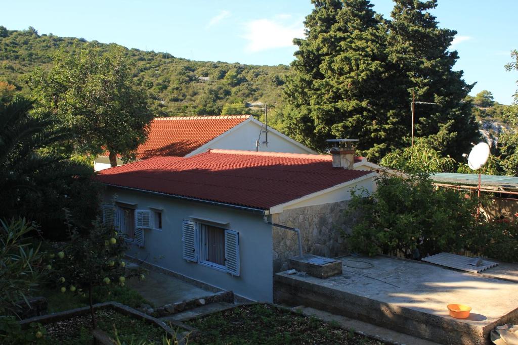 a small blue house with a red roof at Seaside holiday house Cove Rogacic, Vis - 8886 in Vis