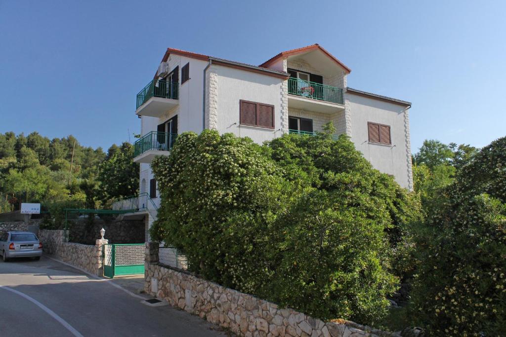un grande edificio bianco sul lato di una strada di Apartment Stari Grad 8780b a Stari Grad (Cittavecchia)