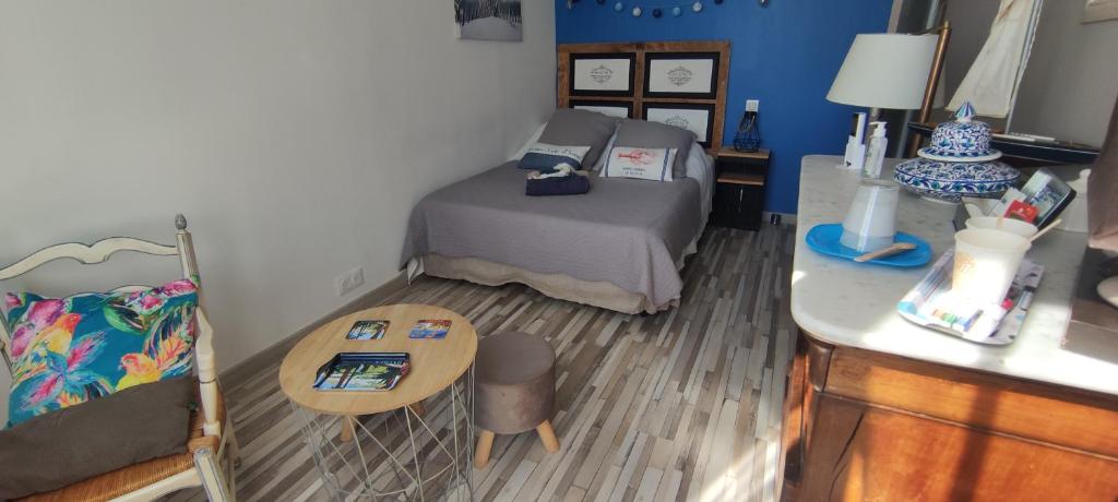 Dormitorio pequeño con cama y mesa en 2 chambres côté plage, en Hyères