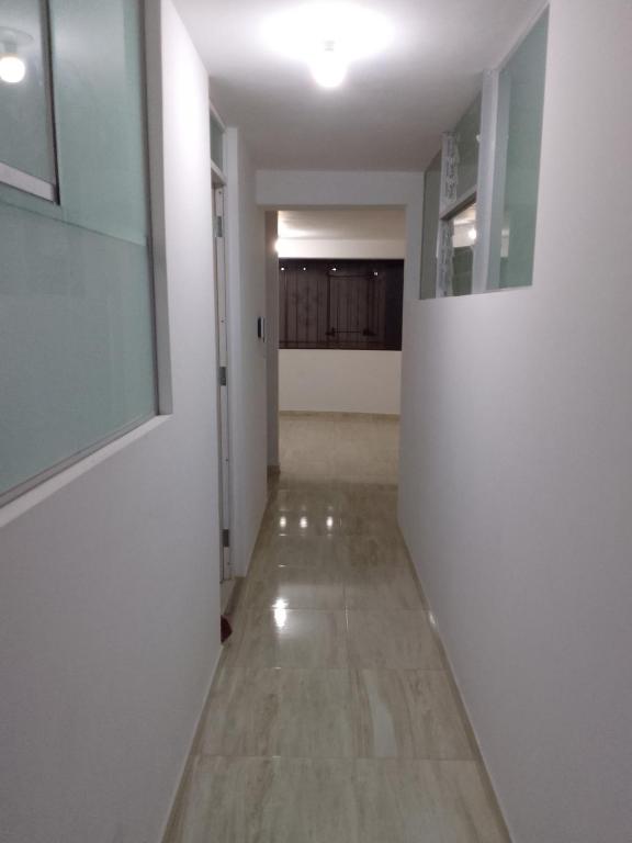 a hallway with white walls and a long hallway with a hallway at Small House in Cusco