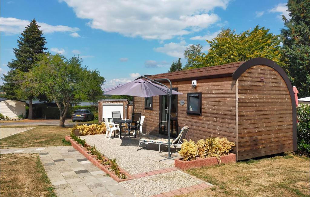 ein kleines Haus mit einer Terrasse und einem Sonnenschirm in der Unterkunft Stunning Home In Haller With Wifi in Haller