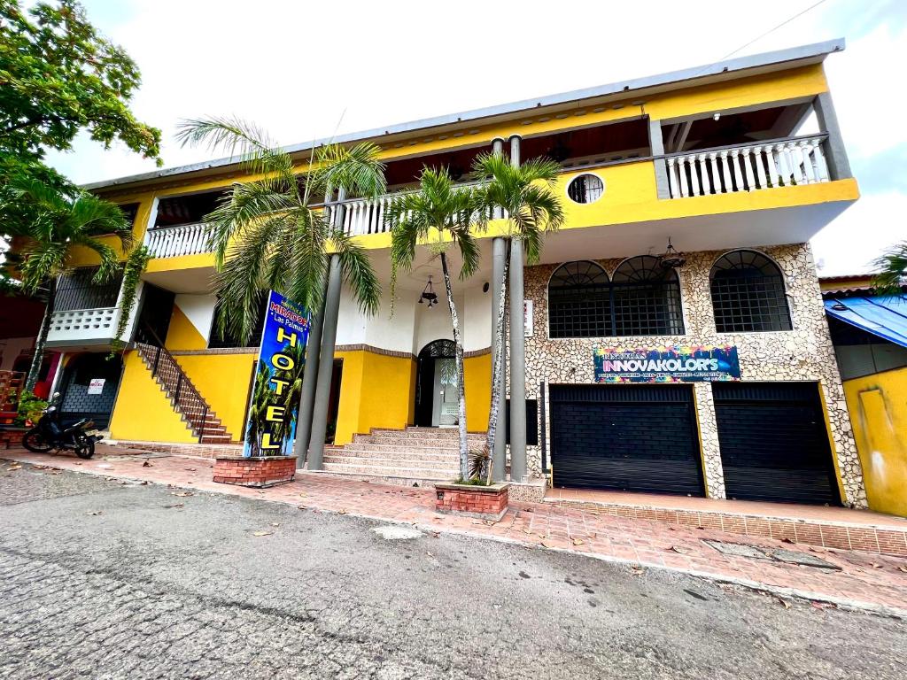 ein gelbes Gebäude mit Palmen davor in der Unterkunft Hotel Boutique Mirador Las Palmas in Honda