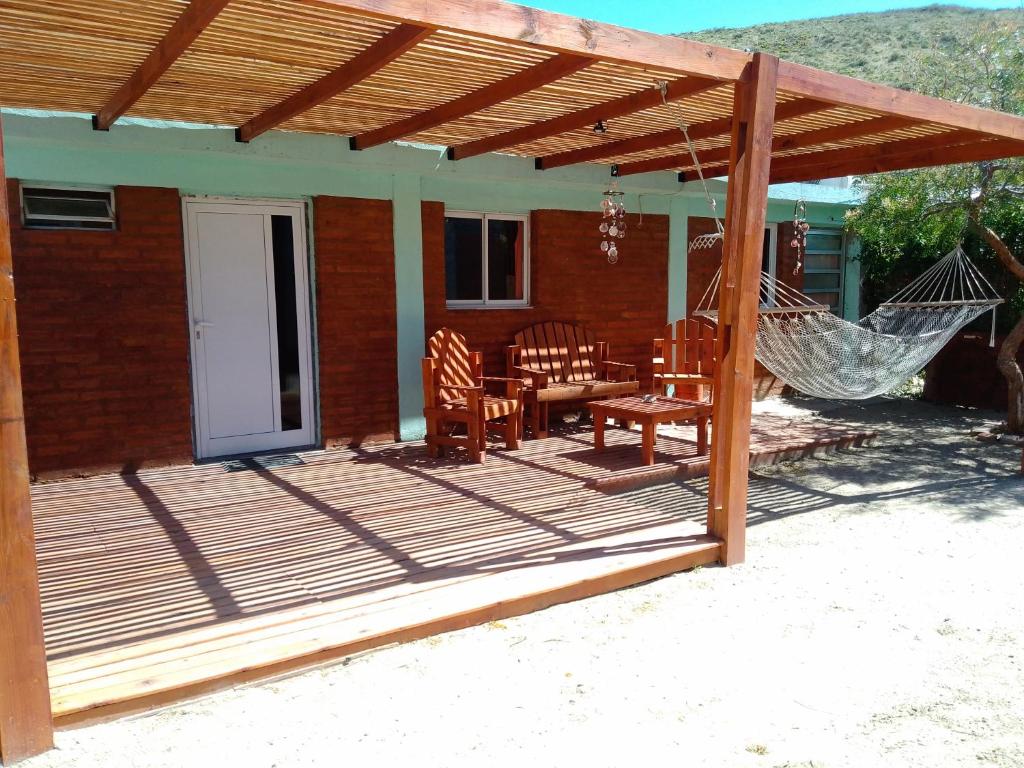 eine Terrasse mit Hängematte und ein Haus in der Unterkunft Antü in Puerto Pirámides