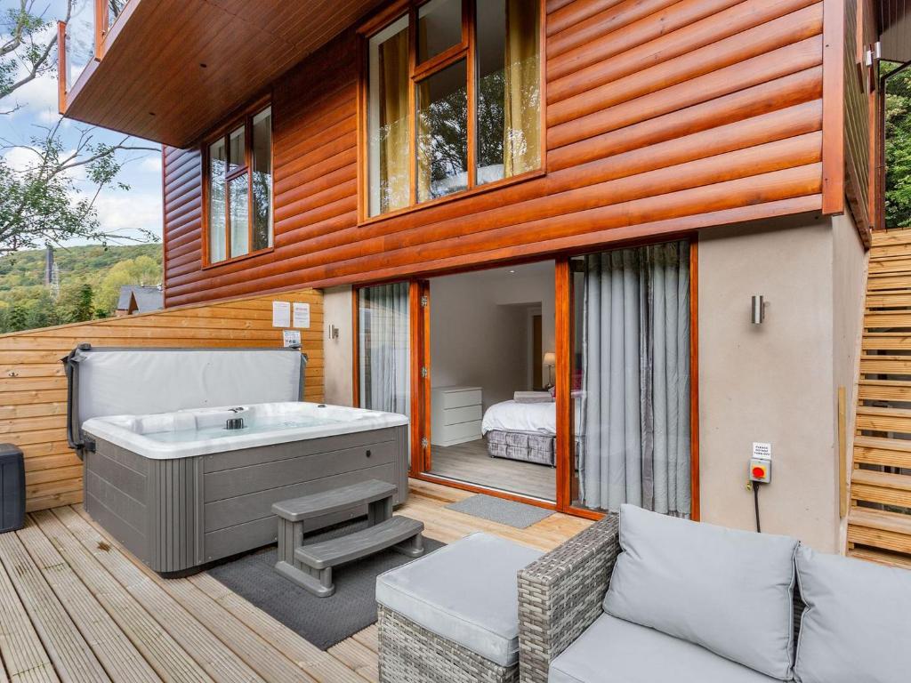 ein Haus mit einer Badewanne auf einer Terrasse in der Unterkunft Waterside Lodge Five -uk38263 in Southowram