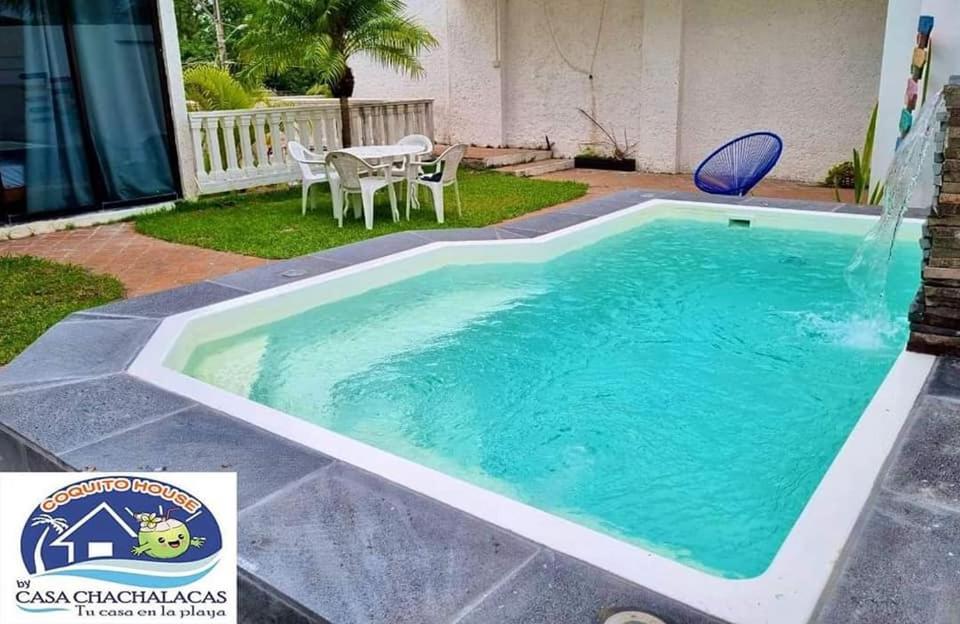 una piscina con una fuente de agua en un patio en COQUITO HOUSE CHACHALACAS, en Chachalacas