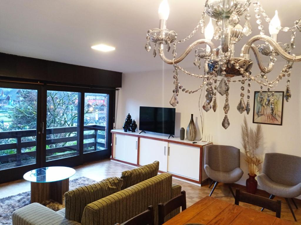 a living room with a chandelier at Mais Incrível Localização de Gramado in Gramado