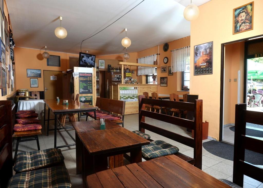 a restaurant with wooden tables and benches in a room at Hotel U Jezírka in Liberec