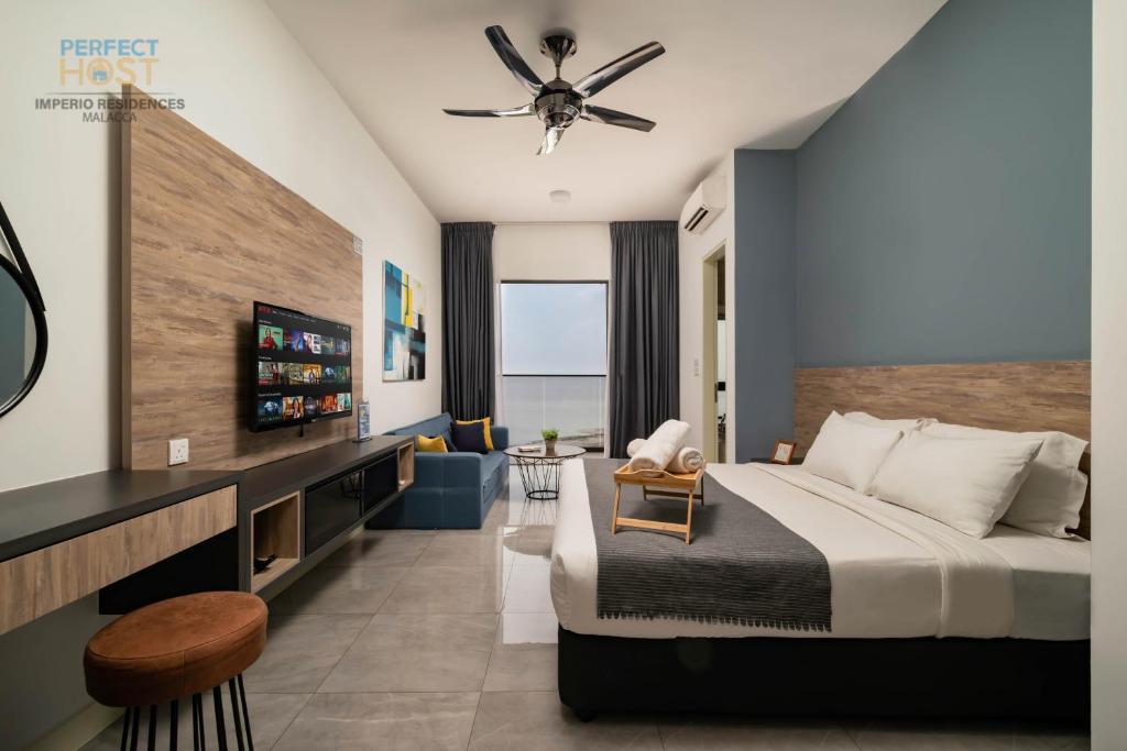 um quarto de hotel com uma cama e uma televisão em Imperio Residence Seafront by Perfect Host em Malaca