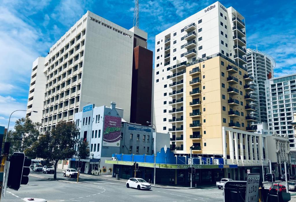 una ciudad con edificios altos y una calle con coches en Akara Perth, en Perth