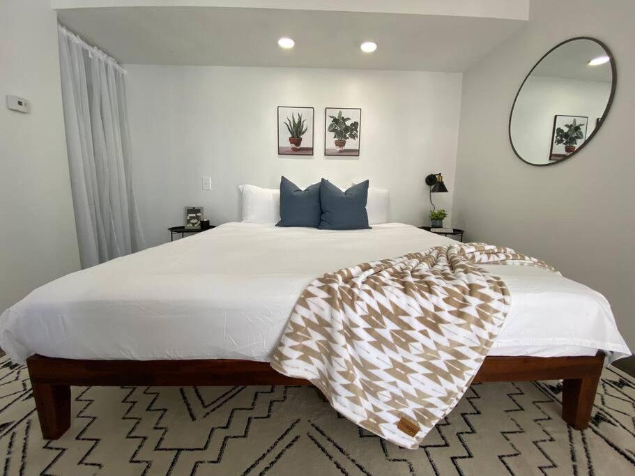 a bedroom with a large white bed and a mirror at Magnolia Suiteking Bednrgmed Center1st Floor in Houston
