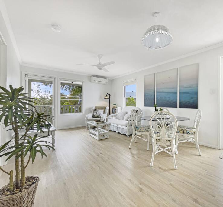 una sala de estar blanca con mesa y sillas en Studio Seaside Self-contained apartment, en Marcoola