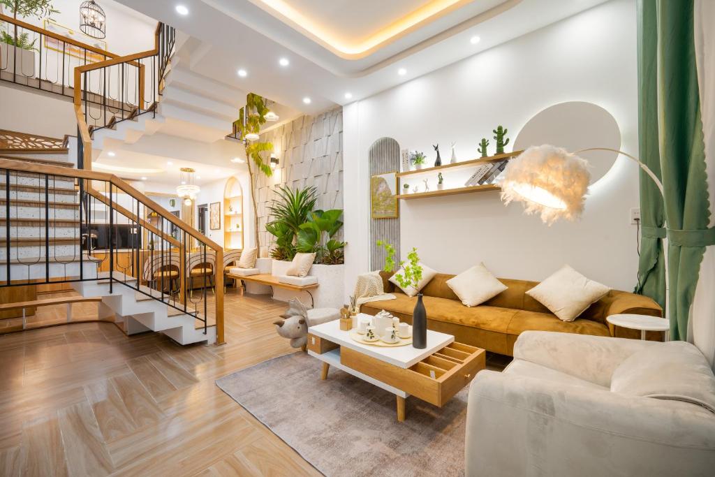sala de estar con sofá y escalera en Gạo House Homestay Đà Nẵng gần sân bay và trung tâm thành phố en Da Nang