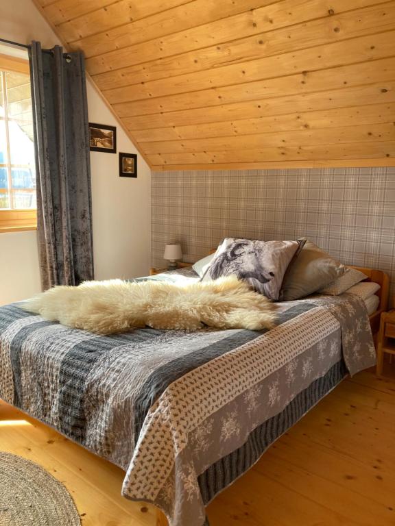 Bett in einem Zimmer mit Holzdecke in der Unterkunft Ciche Pole in Maniowy