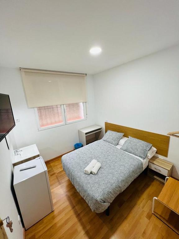 1 dormitorio con 1 cama con 2 toallas en HOSPEDAJE COLONIA VALLECAS, en Madrid