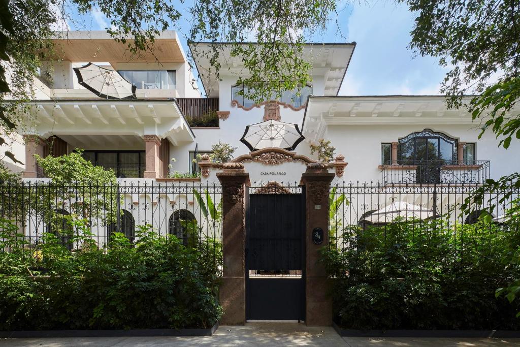 ein Haus mit einem schwarzen Tor und einem Zaun in der Unterkunft Casa Polanco Hotel Boutique in Mexiko-Stadt