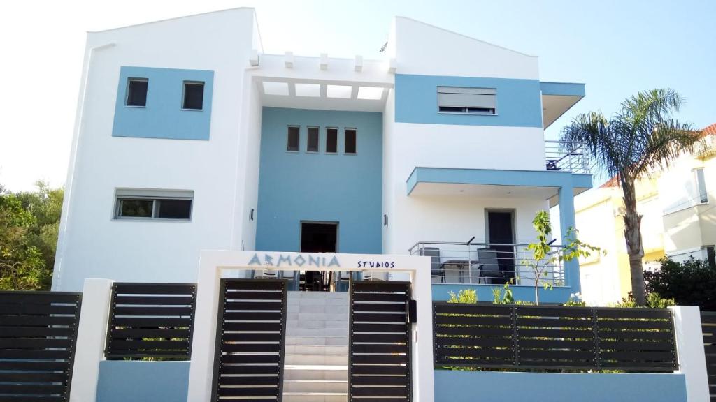 a white and blue house with a sign in front of it at Armonia Studios Preveza in Preveza