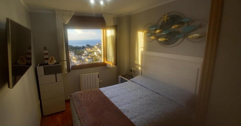 1 dormitorio con cama y ventana en LUARCAPLAYA APARTAMENTO Plazas de garaje incluidas, en Luarca