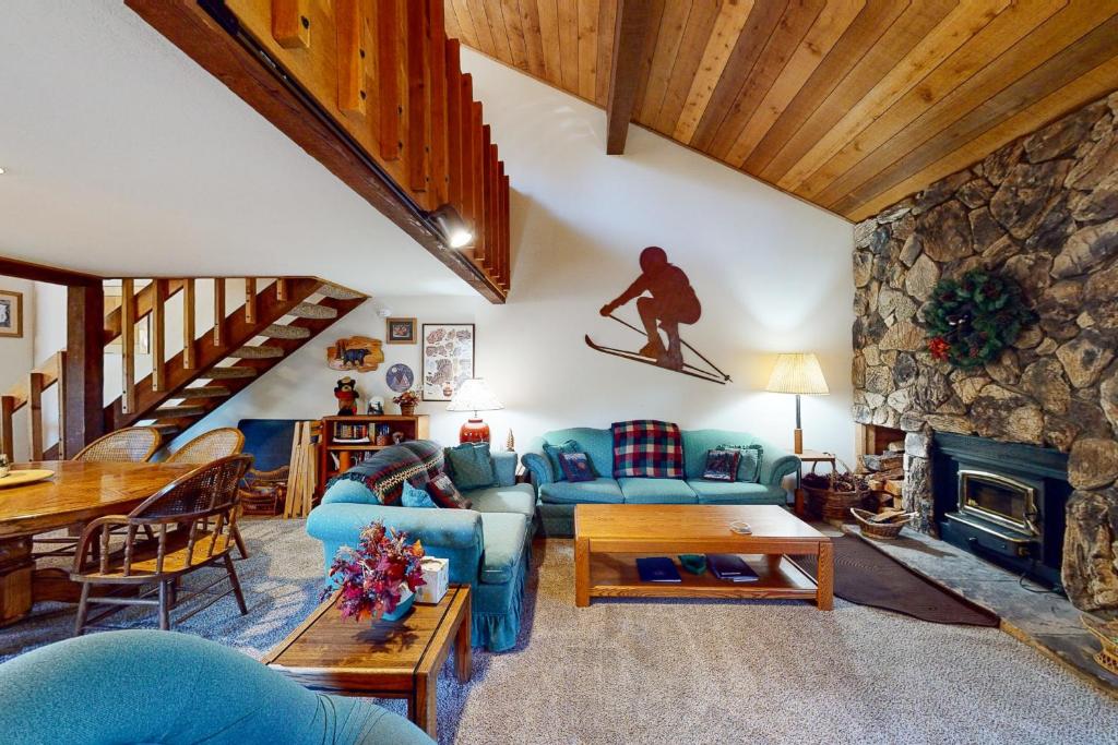 a living room with a blue couch and a skateboard on the wall at Snowcreek 56 in Mammoth Lakes