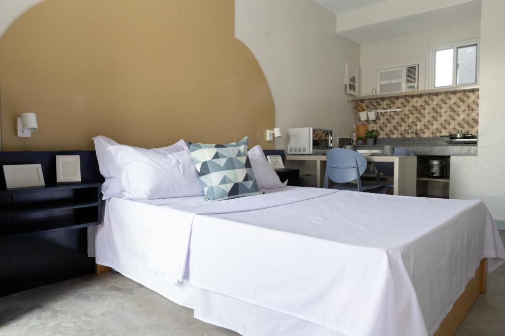 sypialnia z dużym białym łóżkiem i kuchnią w obiekcie Hive Manila Guesthouse -Netflix,400mbps WI-FI w mieście Bacoor