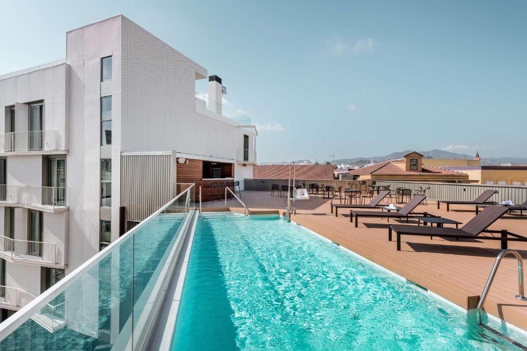 a swimming pool on the roof of a building at NH Málaga in Málaga